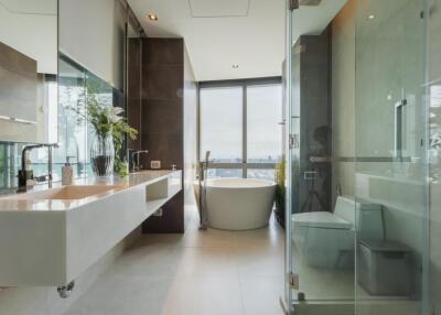 Modern bathroom with large window, glass shower, bathtub, and dual sinks