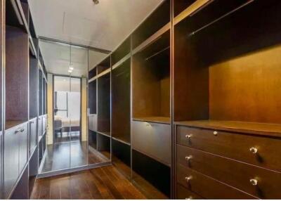 Elegant walk-in closet with wooden shelves and drawers