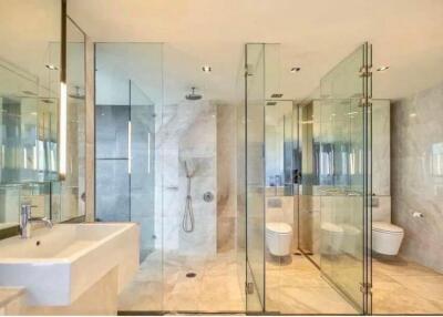 Modern bathroom with glass shower enclosure and twin toilets