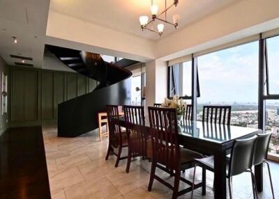 Spacious dining area with large windows and a spiral staircase