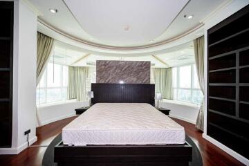 Modern master bedroom with large windows and built-in shelves