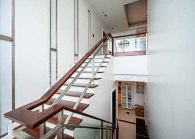 Modern staircase with glass railing and wooden steps