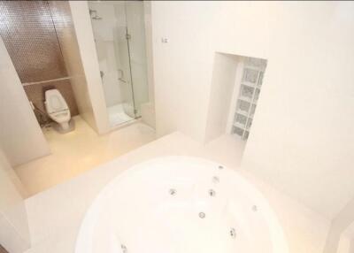 Modern bathroom with a jacuzzi tub, shower, and toilet