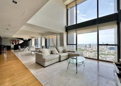 Spacious modern living room with large windows, city views, and contemporary furnishings