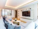 Modern living room with large flat-screen TV, white furnishings, and decorative accents