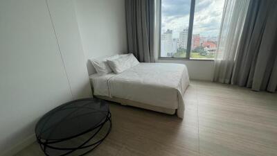 Modern bedroom with a large window and city view