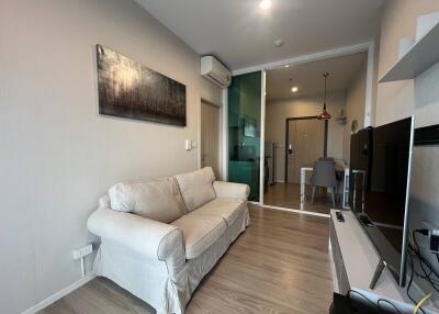 Modern living room with white sofa, air conditioning, and TV