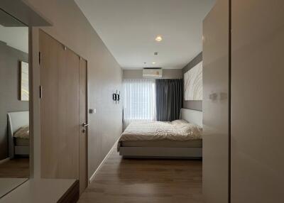 Modern bedroom with bed, wardrobe, and large window