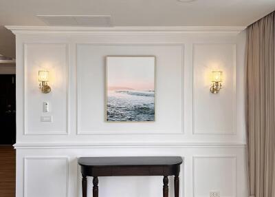 A living area with elegant wall paneling, a wooden console table, and wall-mounted lighting fixtures