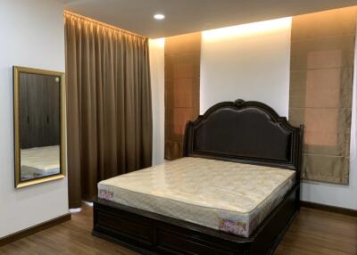 Spacious bedroom with a large bed and mirrored wardrobe