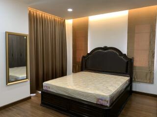 Spacious bedroom with a large bed and mirrored wardrobe