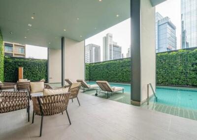 Covered outdoor lounge area with swimming pool in modern city building