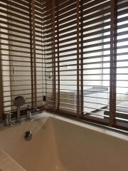 Modern bathroom with bathtub and wooden blinds