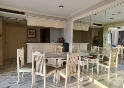 Spacious dining area with white marble flooring and mirrored wall