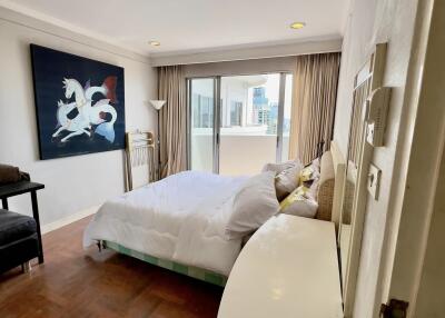 Bedroom with a large bed, wall art, and a window opening to a balcony