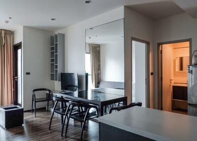 Modern open-plan living area with dining table and adjacent kitchen