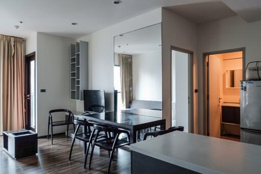 Modern open-plan living area with dining table and adjacent kitchen