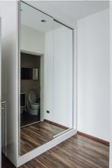 Hallway with mirrored wardrobe and view into bathroom