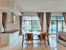 Open-plan kitchen and dining area with large windows and a view of the pool