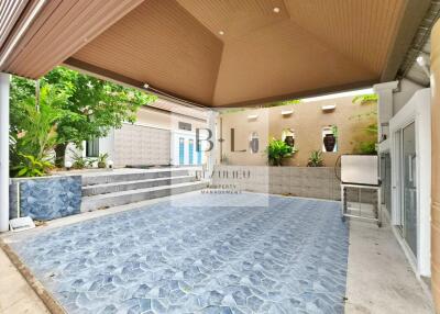 Covered outdoor area with tiled flooring and decorative walls