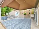 Covered outdoor area with tiled flooring and decorative walls