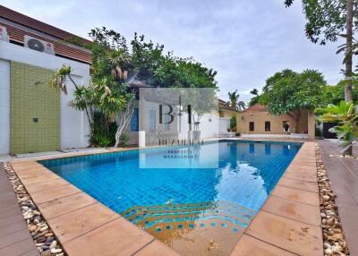 Outdoor swimming pool with surrounding tropical vegetation