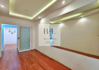 Well-lit hallway with wooden flooring and sliding door