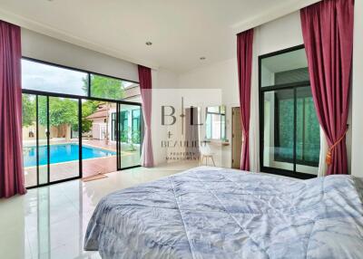 Bedroom with pool view and large windows