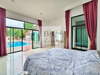 Bedroom with pool view and large windows