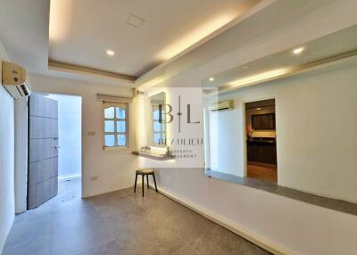 Modern living room with large mirror and open doorway to kitchen