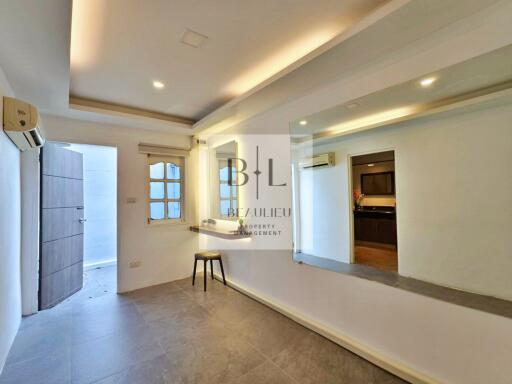 Modern living room with large mirror and open doorway to kitchen