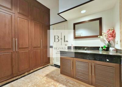 Elegant bathroom with wooden cabinets and black countertop