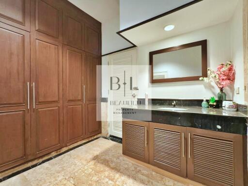 Elegant bathroom with wooden cabinets and black countertop