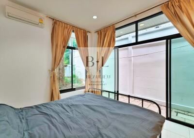 Bedroom with large windows and grey bedspread