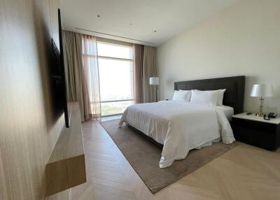 Spacious bedroom with large window, a comfortable bed and modern furnishings