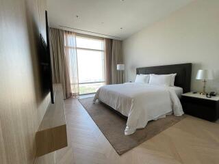 Spacious bedroom with large window, a comfortable bed and modern furnishings