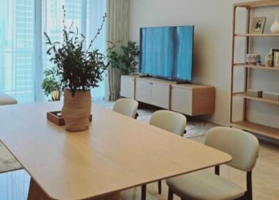 Modern living room with dining table, TV, and shelving