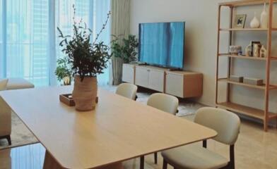 Modern living room with dining table, TV, and shelving