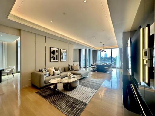 Modern living room with a large sofa, coffee tables and dining area