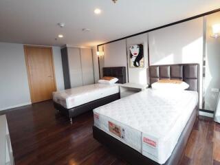 Two-bed bedroom with modern decor and wooden flooring