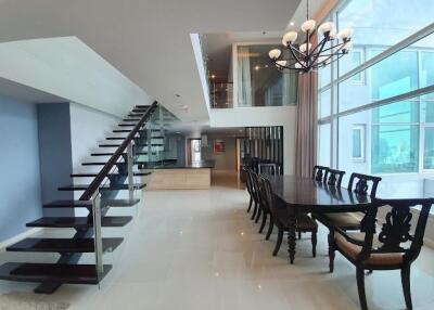 Modern dining area with glass staircase and large windows