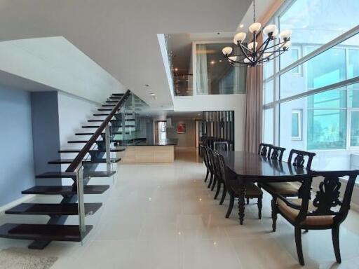 Modern dining area with glass staircase and large windows