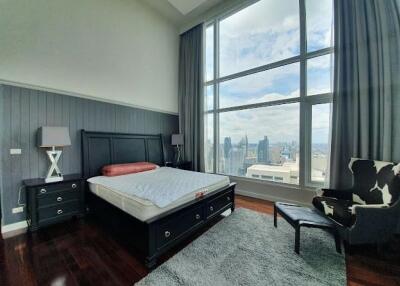 Modern bedroom with large floor-to-ceiling window offering a city view