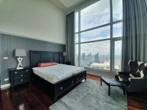 Modern bedroom with large floor-to-ceiling window offering a city view