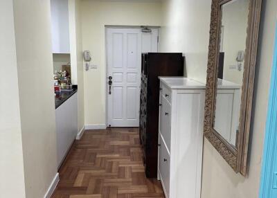 Hallway with wooden parquet flooring and a large mirror