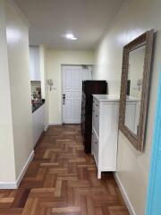 Hallway with wooden parquet flooring and a large mirror