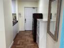 Hallway with wooden parquet flooring and a large mirror