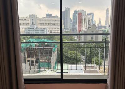 A window view showing a city skyline and buildings in the distance