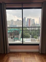 A window view showing a city skyline and buildings in the distance