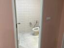 Bathroom with white tiled walls and toilet